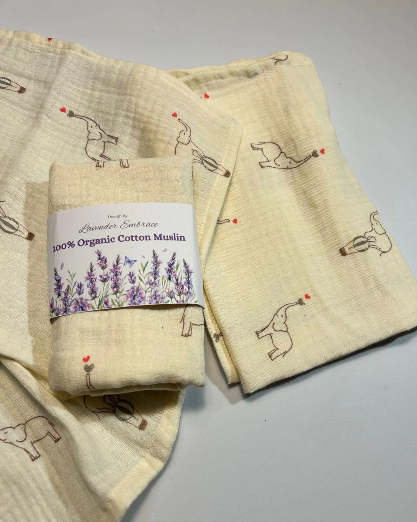 Folded organic cotton muslin with printed designs on a gray background